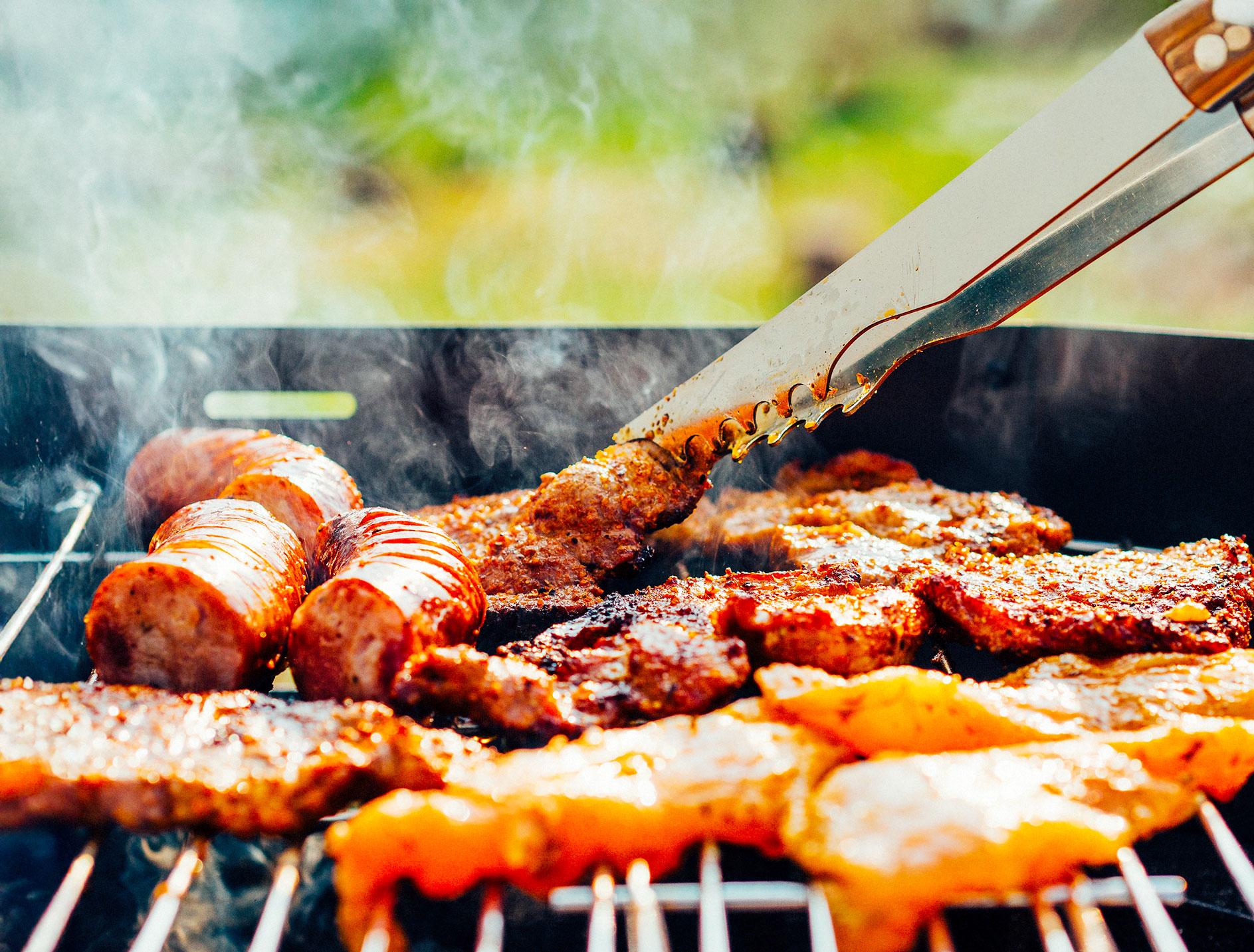 grillade de viande barbecue avec saucisses, côtelettes et marinade en cuisson